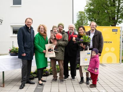 Ein Gruppenfoto mit Vertretern der Wohnungsgenossenschaft, der Politik und einer Familie, die in ihr neues Zuhause einzieht.