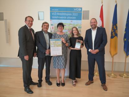Die Preisträgerinnen halten bei einem Gruppenfoto die Urkunde und den Preis in der Hand, auch Bürgermeister Stadler und weitere am Siegerprojekt beteiligte Personen sind über die Auszeichnung sichtlich erfreut.