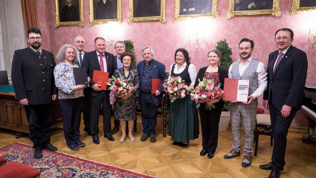 Gruppenfoto mit allen Ehrenzeichen- und Preisträger:innen, dem Bürgermeister und den beiden Vize-Bürgermeistern.