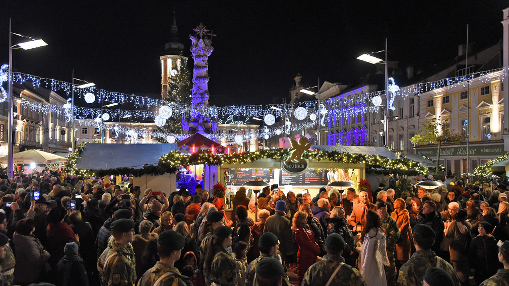 Der beleuchtete Christkindlmarkt am Rathausplatz mit BesucherInnen. (Foto: Josef Vorlaufer)