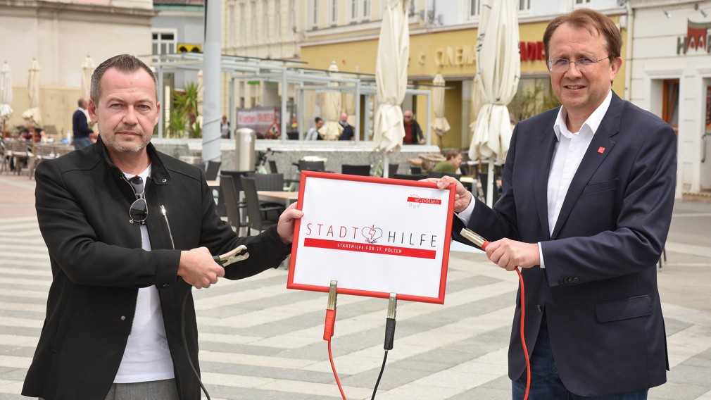 Bürgermeister Matthias Stadler und Michael Bachel vom Wirtschaftsservice mit Schild am Rathausplatz. (Foto: Vorlaufer)