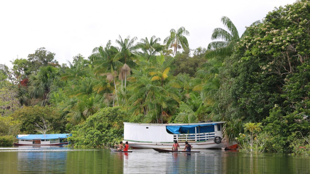 Menschen mit Booten im Rio Negro.(Foto: Klimabündnis Österreich)