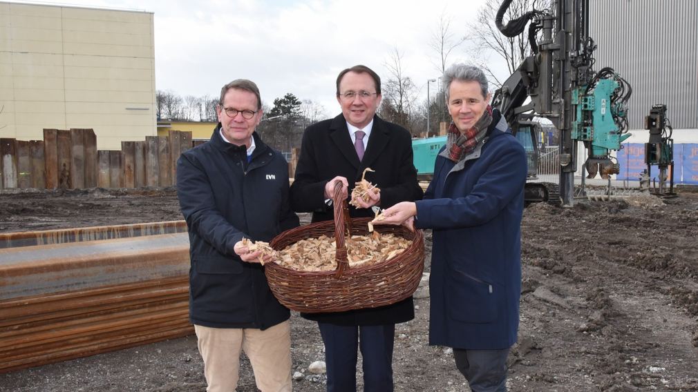 Drei Personen mit Hackschnitzel auf einer Baustelle. (Foto: Vorlaufer)