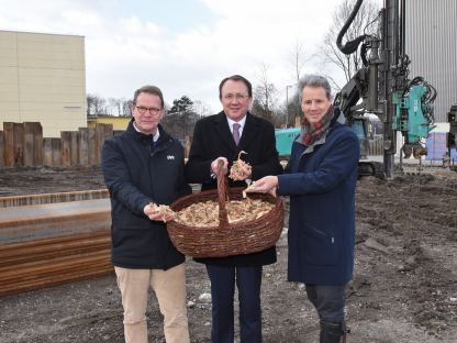 Drei Personen mit Hackschnitzel auf einer Baustelle. (Foto: Vorlaufer)