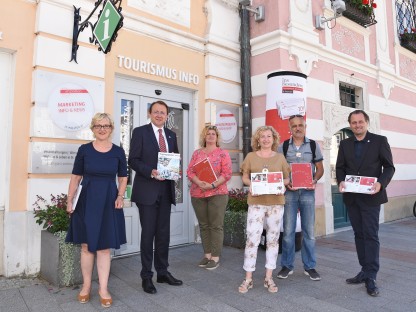 Eine Abordnung aus dem Rathaus präsentiert den neuen Tagungsfolder vorm Tourismusbüro. (Foto: Vorlaufer)