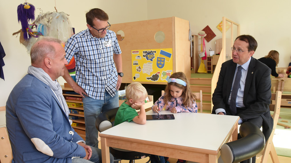 Kinder entdecken die Lernwelt von Letto, Erwachsene sehen dabei zu.