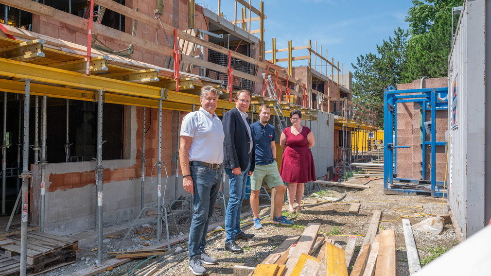 Geschäftsführer der Immobilien St. Pölten GesmbH Martin Sadler, Bürgermeister Matthias Stadler, Bauleiter der Swietelsky AG Markus Horinek und die Leiterin des Seniorenwohnheims Bettina Lahnsteiner stehen für ein Gruppenfoto auf der Baustelle des neuen Hauses beim Seniorenwohnheim Stadtwald.