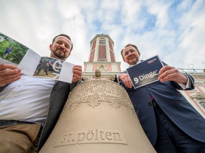 Zwei Personen mit Glocke vor dem Rathausturm. (Foto: Kalteis)