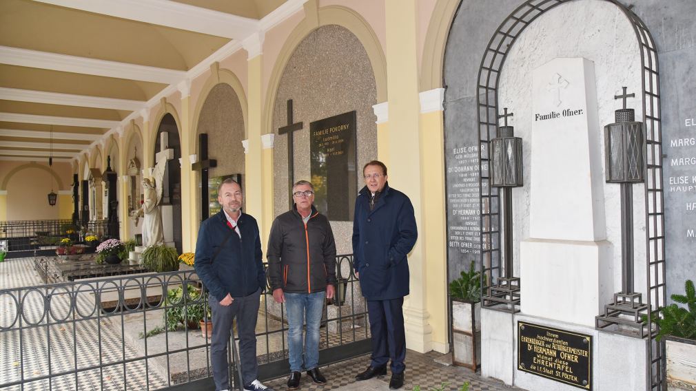 Drei Herren stehen bei den renovierten Arkaden am Hauptfriedhof.