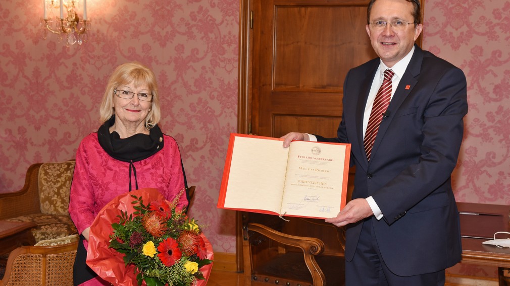 Bürgermeister Matthias Stadler hält Urkunde, Eva Riebler-Übleis hält einen Blumenstrauß. Beide stehend im Bürgermeisterzimmer. (Foto: Josef Vorlaufer)