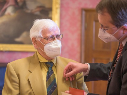 Bürgermeister Matthias Stadler steckt die Nadel mit dem Ehrenzeichen der Stadt St. Pölten an das Jackett von Gustav Schlachtner an. (Foto: Arman Kalteis)