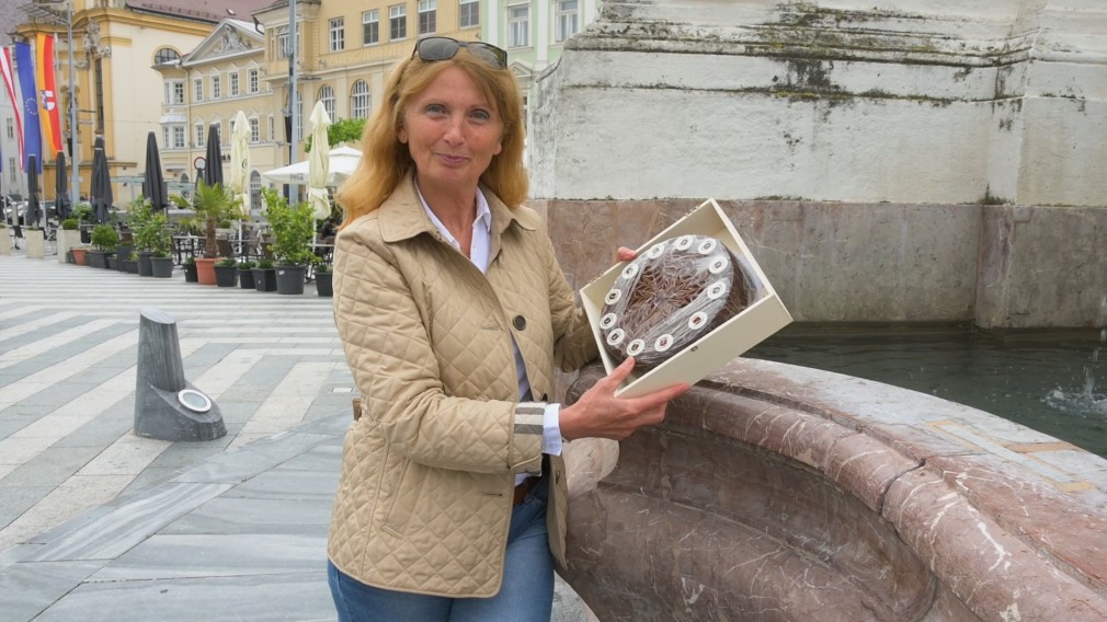 Themenbegleiterin Anita Schuster mit einer Prandtauertorte am Rathausplatz. (Foto: A. Behpournia)