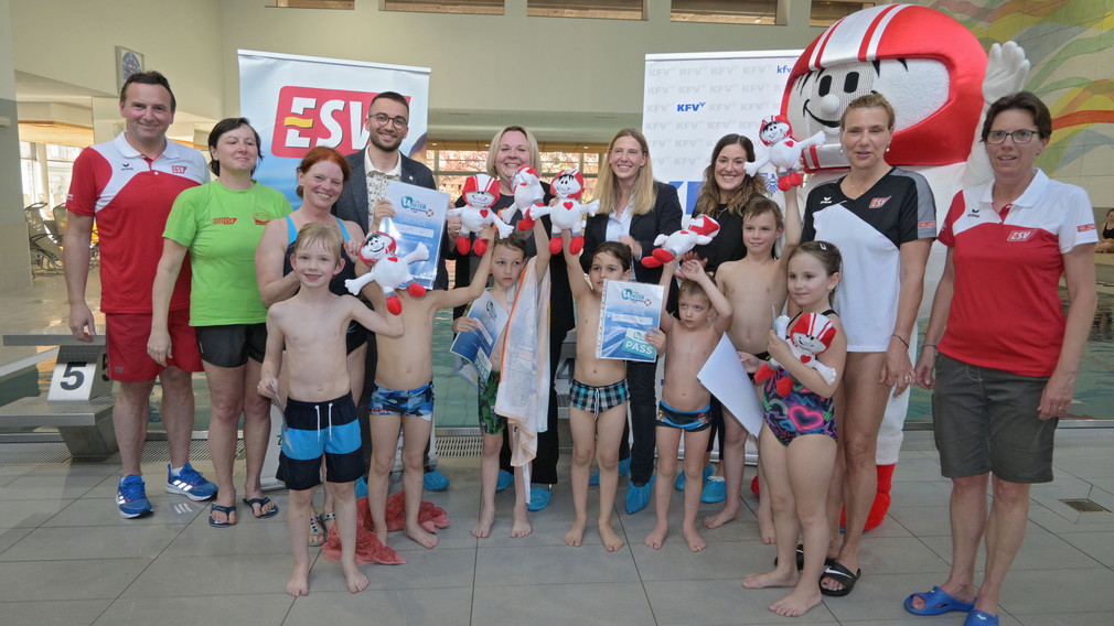 Ein Mädchen, das an einem Selbstrettungsschwimmtraining teilnimmt, springt in ein Schwimmbecken.