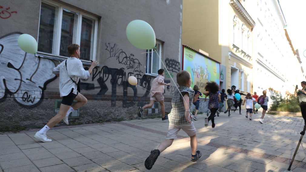 Laufende Kinder mit am Handgelenk befestigten Luftballonen. Fotos: Florian Dalik