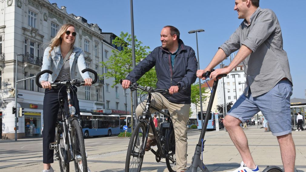Drei Personen stehen mit Fahrrädern und einem Roller am Bahnhofplatz in St. Pölten. (Foto: Josef Vorlaufer)