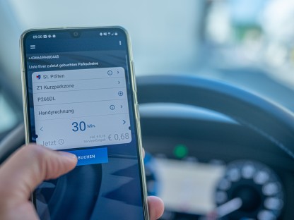 Ein Autolenker bucht mit dem Handy ein Parkticket.