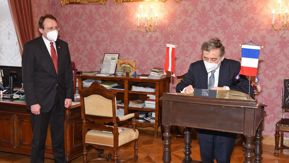 Bürgermeister Matthias Stadler steht neben dem französischen Botschafter Gilles Pécout, der sich in das Goldene Buch der Stadt einträgt. (Foto: Josef Vorlaufer)