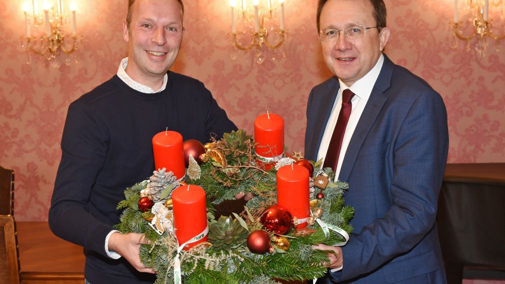 Jürgen Rauch überreicht Bürgermeister Matthias Stadler den alljährlichen Adventkranz von „bellaflora“. (Foto: Josef Vorlaufer)