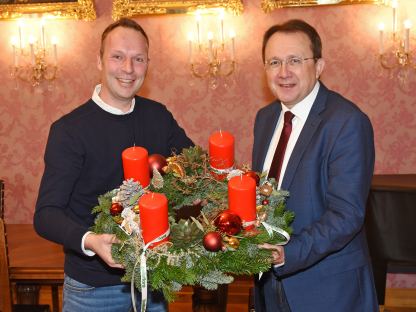 Jürgen Rauch überreicht Bürgermeister Matthias Stadler den alljährlichen Adventkranz von „bellaflora“. (Foto: Josef Vorlaufer)