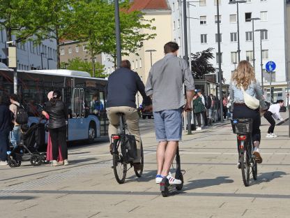 Drei Personen auf rollern und Rädern vor dem Bahnhof St. Pölten. (Foto: Josef Vorlaufer)
