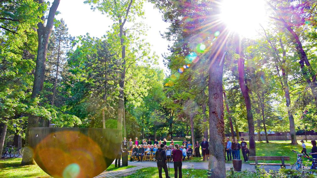 Das Bild zeigt die Gedenkstätte im Hammerpark sowie die Gäste der Veranstaltung. Foto: Josef Vorlaufer