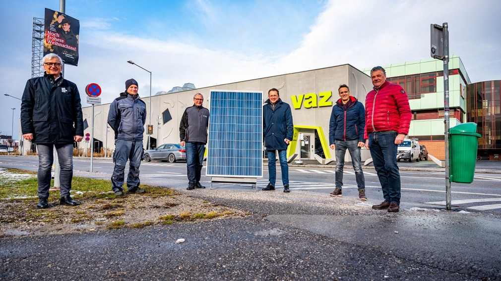 Sechs Herren vor dem VAZ mit einem Solarpanel der Photovoltaikanlage. (Foto: Arman Kalteis)