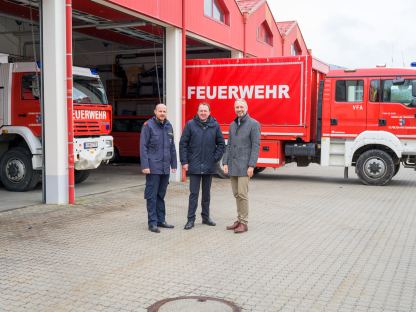 Drei Herren bei den Garagen der FF-Pottenbrunn, im Hintergrund stehen Feuerwehrfahrzeuge.
