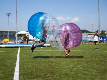 zwei Jugendliche hüpfen geschützt durch einen aufgeblasenen Ganzkörperball aufeinander zu (Foto: Andreas Simon)