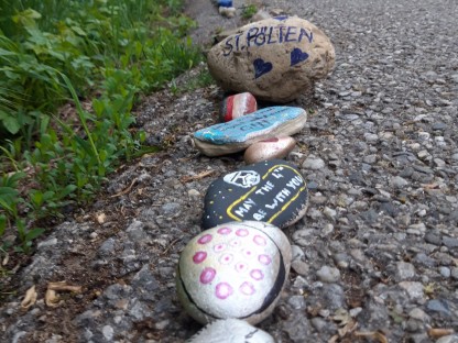 Bemalte Steine auf einem Asphaltweg. Foto: Matthias Stadler