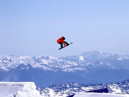 Snowboarder Julian Maschl beim Sprung mit verschneiter Berglandschaft