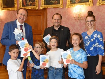 Bürgermeister Matthias Stadler, Leiter des Geschäftsbereichs V/4 Kultur und Bildung Alfred Kellner und Elisabeth Pöcksteiner präsentieren gemeinsam mit vier Kindern das neue Saisonprogramm von Jeunesse. (Foto: Josef Vorlaufer)