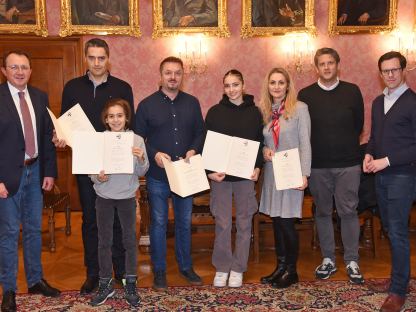 Bürgermeister Matthias Stadler, Kenan Cenanovic, Tarik Cenanovic, Ernest Sehmehmedovic, Nejla Cenanovic, Indira Cenanovic, Referent für Feuerwehren Roland Kormesser und Präsidialabteilungsleiter Michael Koppensteiner bei der Urkundenübergabe. (Foto: Josef Vorlaufer)