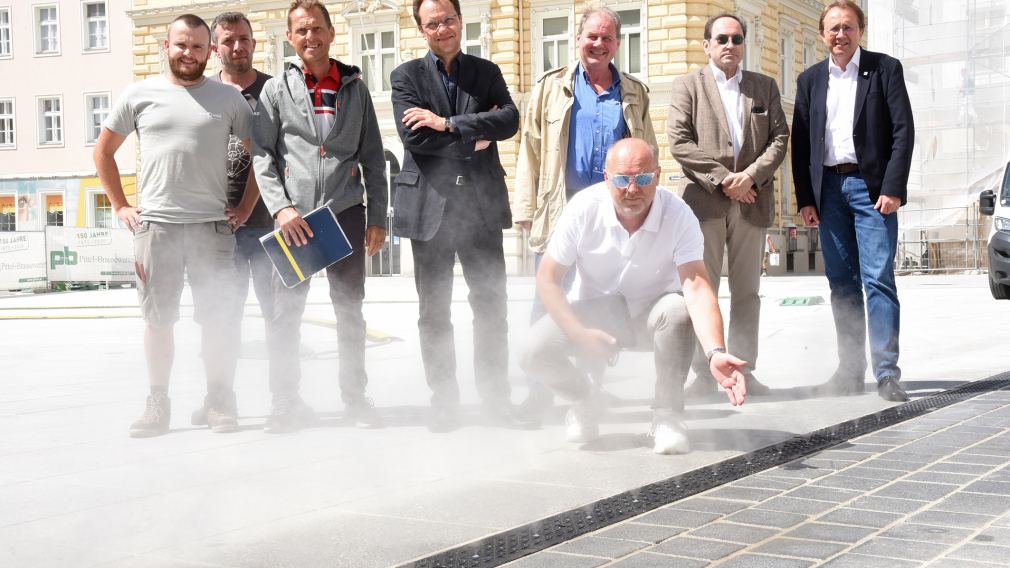 Acht Personen posieren für ein Foto bei der neuen Sprühnebelanlage (Foto: Josef Vorlaufer)