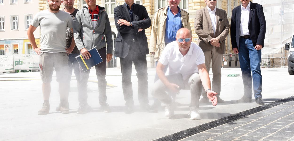 Acht Personen posieren für ein Foto bei der neuen Sprühnebelanlage (Foto: Josef Vorlaufer)