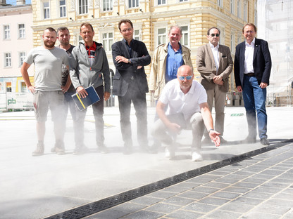 Acht Personen posieren für ein Foto bei der neuen Sprühnebelanlage (Foto: Josef Vorlaufer)