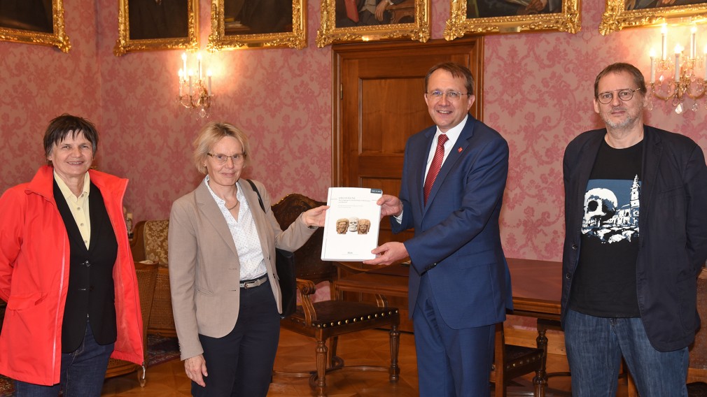 Univ.-Prof. Dr. Claudia Theune und Mag. Sivlia Müller von der Österreichischen Gesellschaft für Mittelalterarchäologie sowie Stadtarchäologe und Mitherausgeber Dr. Ronald Risy übergaben die gesammelten Werke zu „Leben mit dem Tod“ an Bürgermeister Mag. Matthias Stadler. (Foto: Vorlaufer)