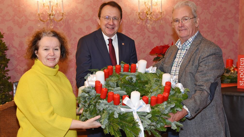 Renate Reuter und Rudolf Leitner von der Evangelischen Pfarrgemeinde A.u.H.B. St. Pölten mit Bürgermeister Matthias Stadler bei der Überreichung des Adventkranzes im Rathaus. (Foto: Josef Vorlaufer)