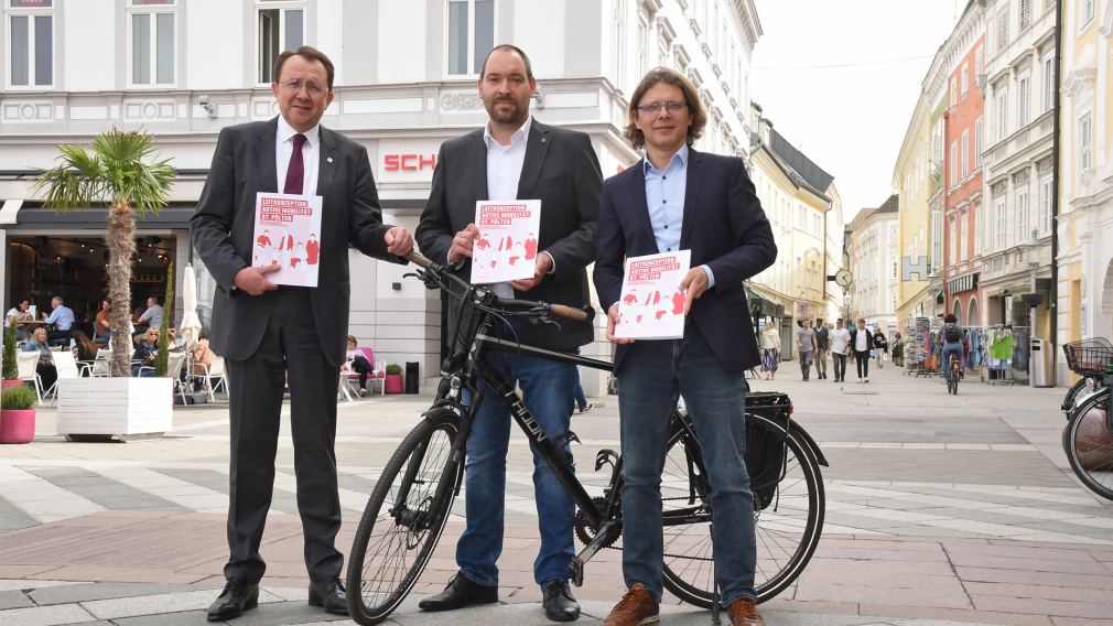 Drei Personen mit Rad am Rathausplatz. (Foto: Vorlaufer)