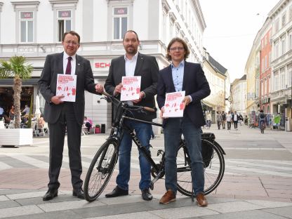 Drei Personen mit Rad am Rathausplatz. (Foto: Vorlaufer)
