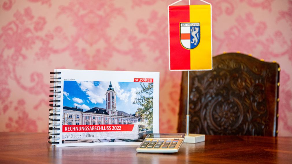 Bild vom Rechnungsabschluss in Druckform un einer St. Pölten Fahne am Tisch. (Foto: Kalteis)