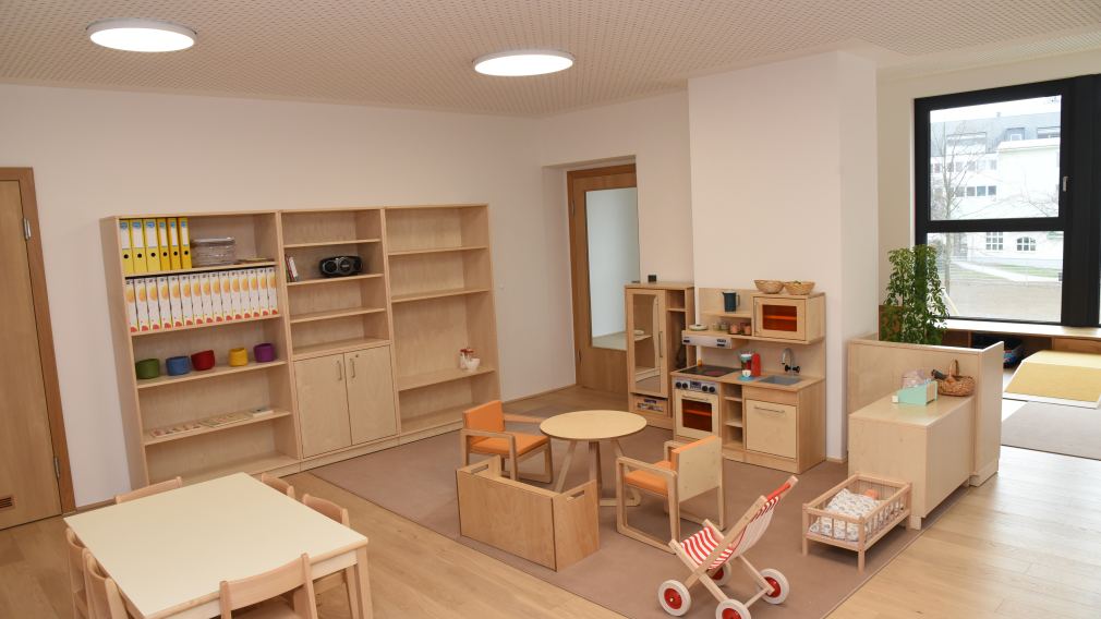 Bürgermeister Matthias Stadler, Baumeister Markus Steinwendtner, Kindergartenleiterin Marion Gnigler und Schulamtsleiter Andreas Schmidt sitzen im neuen Kindergarten mit zwei Kindern. (Foto: Vorlafuer)