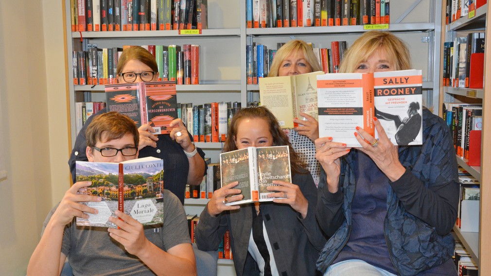 Fünf MitarbeiterInnen der Stadtbücherei verdecken ihren Mund mit Büchern. (Archivbild, Foto Medienservice)