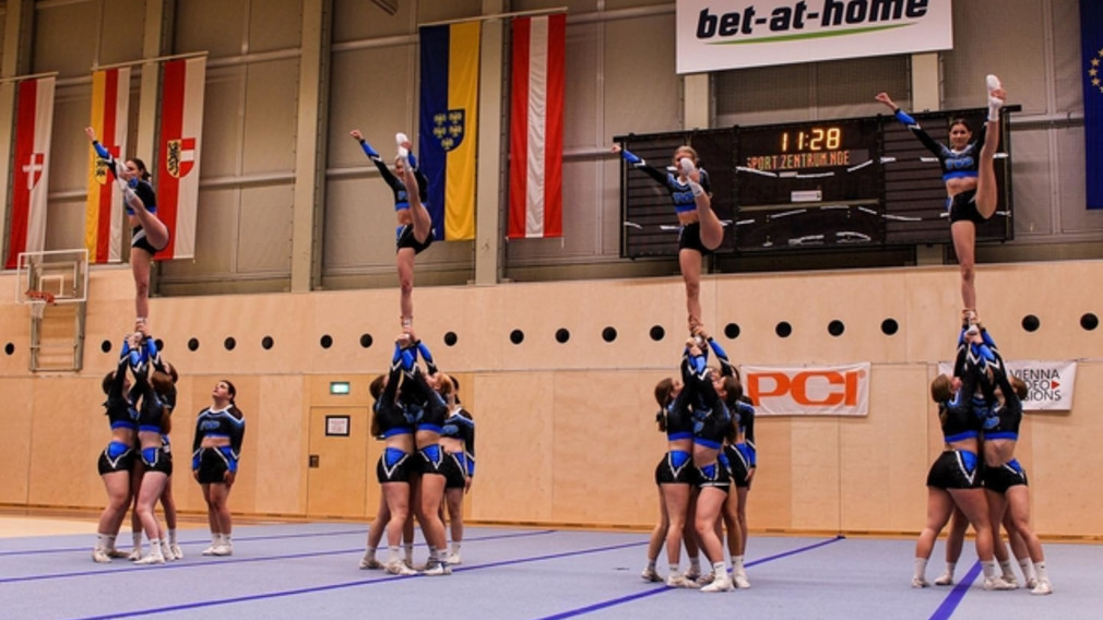 Athletinnen in blauem Sportgewand in vier Gruppen üben eine Cheerleading Position. (Foto: Melanie Wittmann)