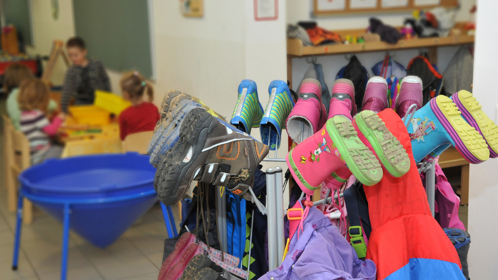 Eine Aufnahme von Stiefeln an einem Kleiderständer in einem Kindergarten. (Foto: Josef Vorlaufer)