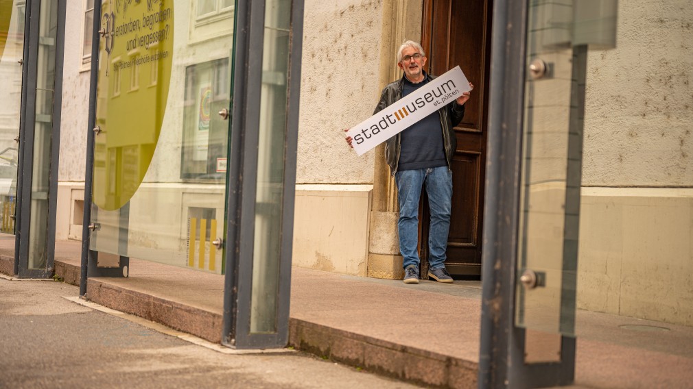 Mag. Thomas Pulle mit einem Schild mit der Aufschrift "Stadtmuseum St. Pölten" in den Händen vor dem Stadtmuseum St. Pölten. (Foto: Arman Behpournia)