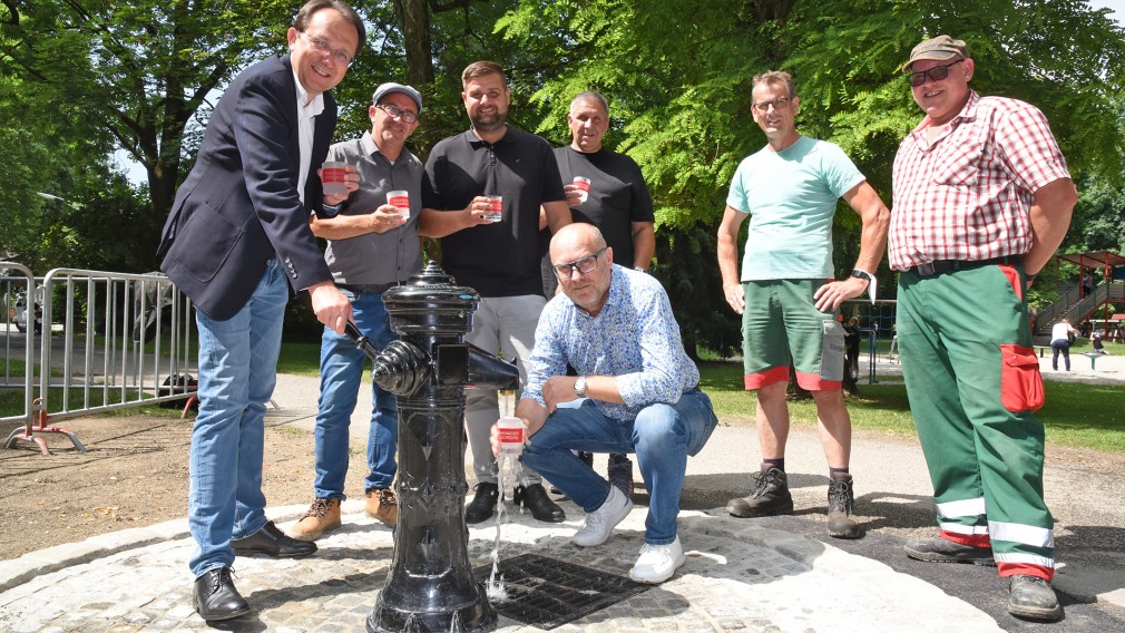 Sieben Personen posieren für ein Foto bei einem Trinkwasserbrunnen. (Foto: Josef Vorlaufer)