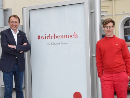 Bürgermeister Matthias Stadler und der Aktionskünstler donhofer. stehen neben einem der Plakate. (Foto Vorlaufer)