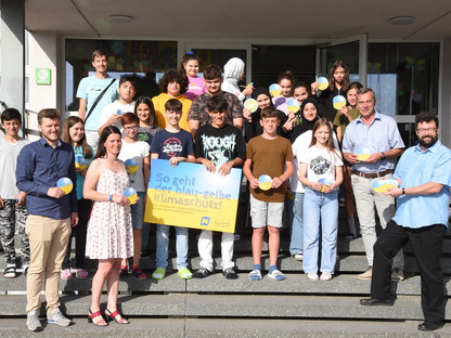 Eine Schulklasse steht mit Vizebürgermeister Harald Ludwig vor einer Schule. (Foto: Josef Vorlaufer)