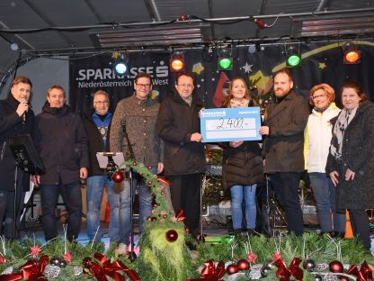 Der Scheck wurde im Beisein einiger Sponsor:innen und des Bürgermeisters am Christkindlmarkt der Sozialhilfe übergeben. (Foto: Josef Vorlaufer)