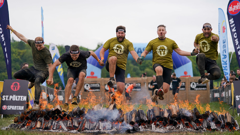 Teilnehmer des Spartan Race beim Sprung über ein brennendes Hindernis. (Foto: Josef Bollwein)